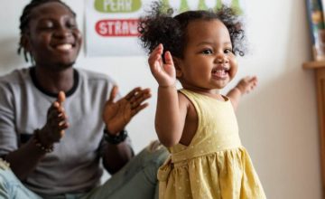 Father clapping while daughter walks