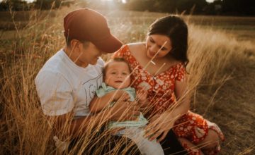 parents and baby grassy field