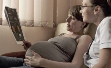 Mother looking at pregnancy exam with doctor